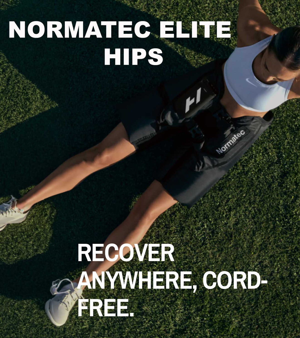 Person wearing Normatec Elite Hips recovery compression boots on green grass.