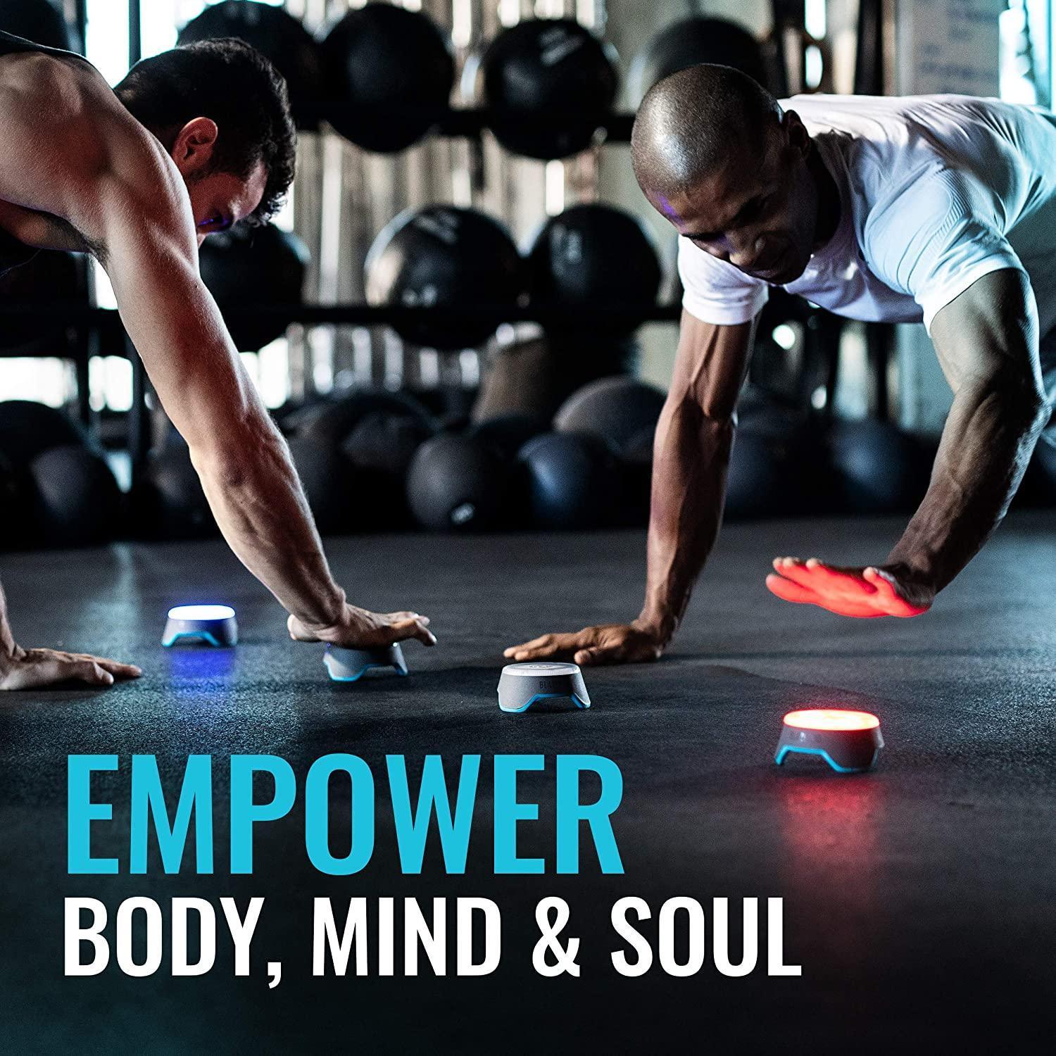 Two athletes in a gym using reaction training lights during a functional fitness workout