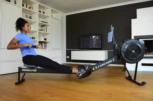 Woman using Concept2 rowing machine for indoor functional fitness workout