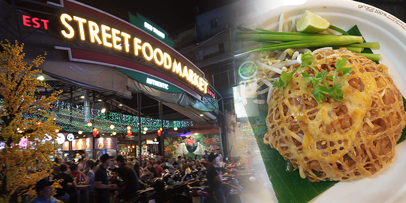 Night street food market with neon sign and a plate of healthy Thai noodles with vegetables
