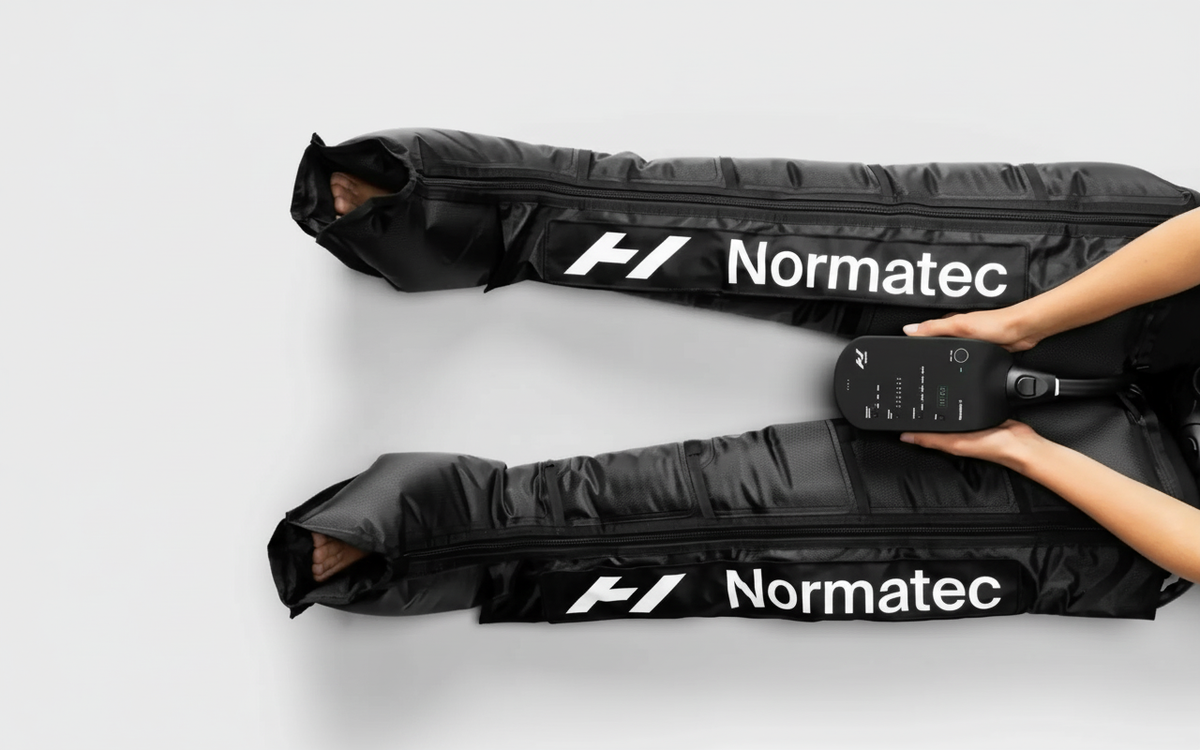 Person using Normatec compression boots for athletic recovery.