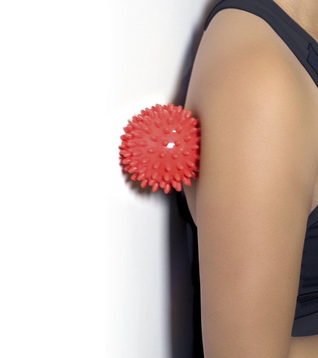 Person using a red spiky massage ball against upper arm for muscle relief