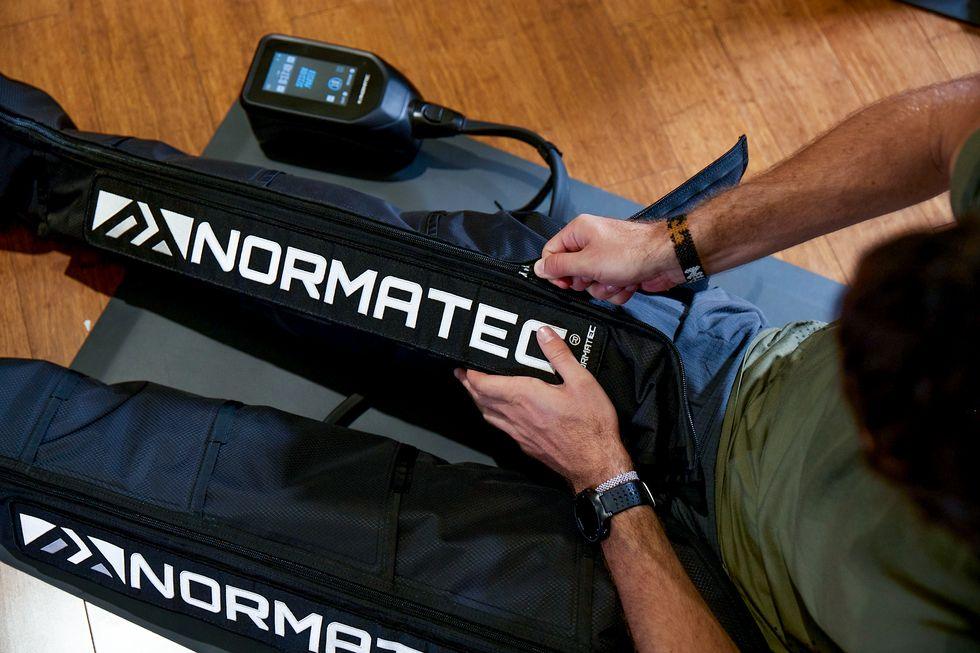 Athlete using Normatec compression leg sleeves for recovery and circulation improvement