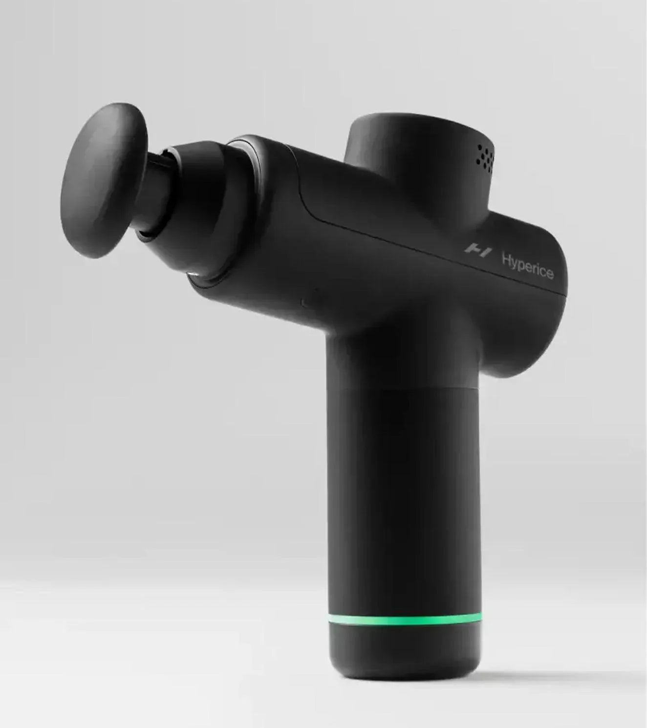 Black percussion massage gun with round attachment on light background