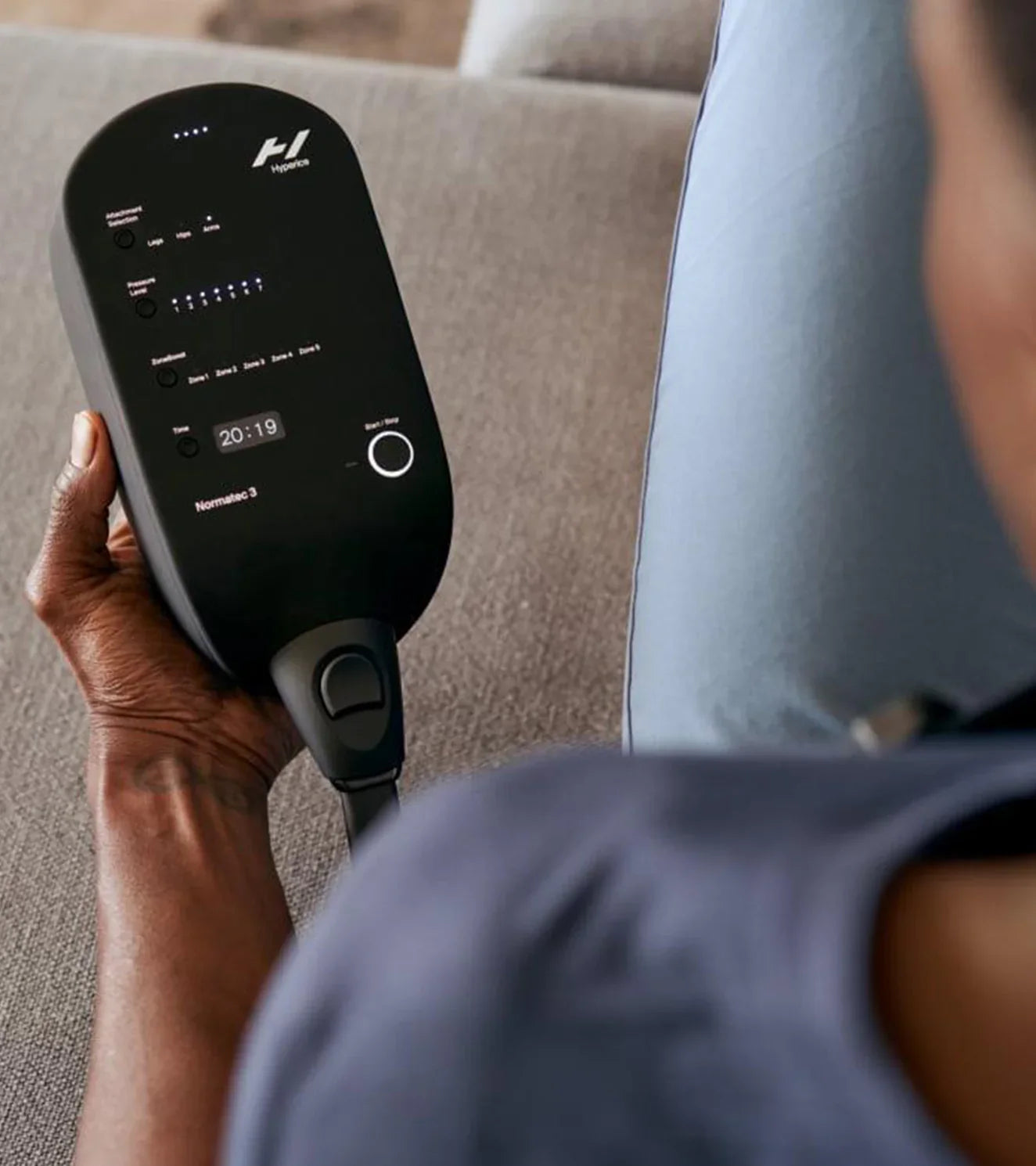 Person using Normatec Pulse 3 recovery and compression therapy device at home