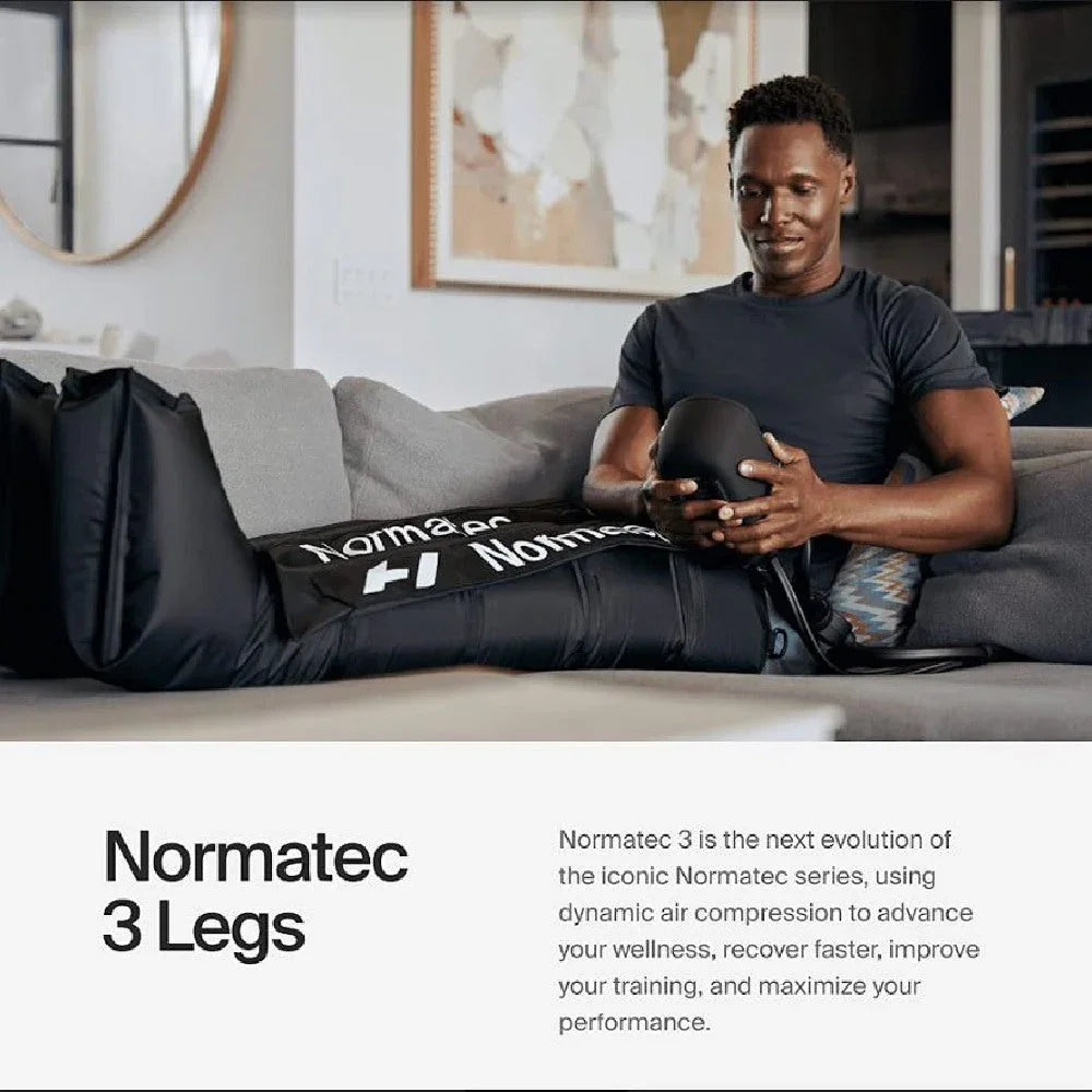 Athlete using Normatec 3 Legs air compression recovery boots on couch for muscle recovery