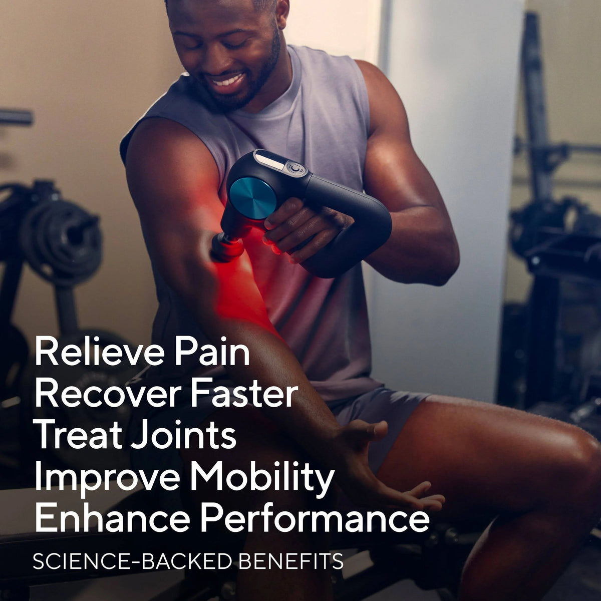 Man using a handheld percussion massage gun on his shoulder for pain relief and recovery.