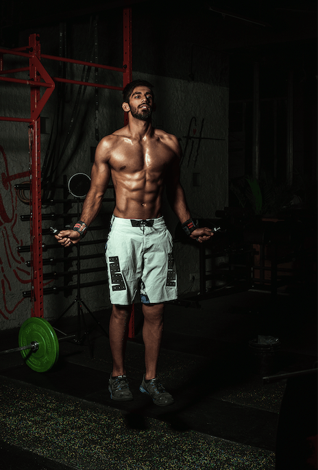 Fit man doing jump rope in gym, functional fitness workout, muscular athlete training