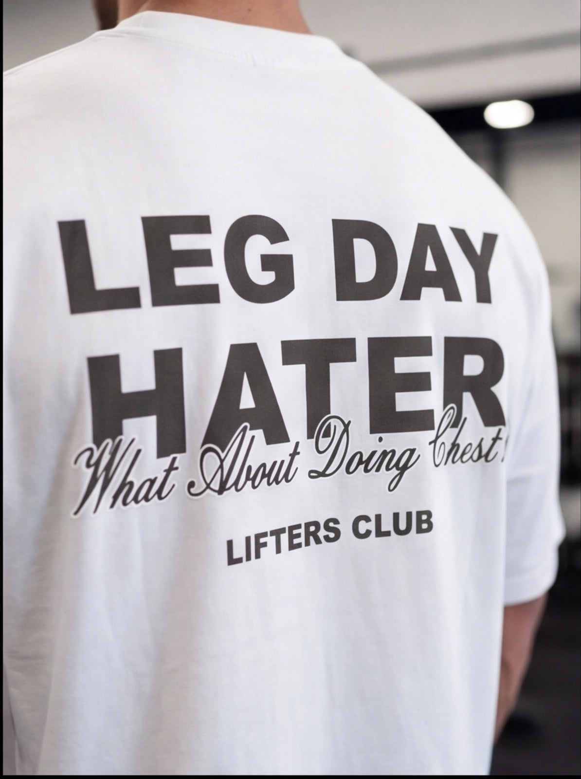 White gym t-shirt with 'LEG DAY HATER' graphic, perfect for lifters and fitness enthusiasts.