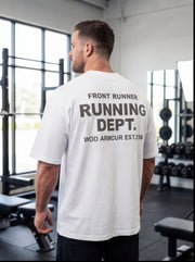 Man wearing white 'Running Dept.' gym t-shirt in fitness studio, functional workout apparel