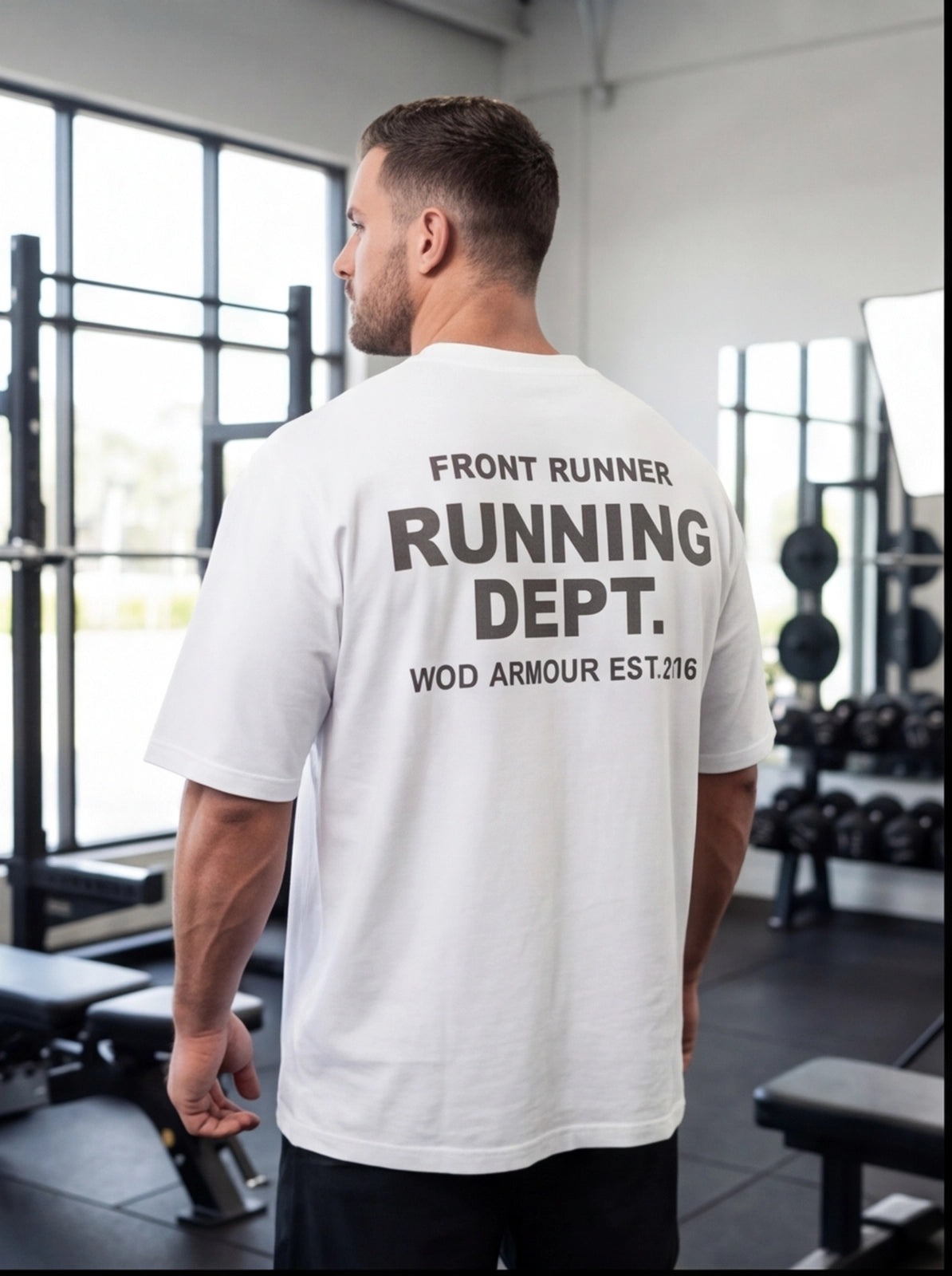 Man wearing white 'Running Dept.' gym t-shirt in fitness studio, functional workout apparel