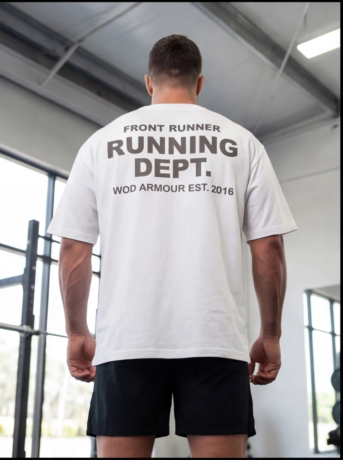 Man wearing white 'Running Dept.' gym t-shirt with 'Front Runner' text, ideal for functional fitness training.