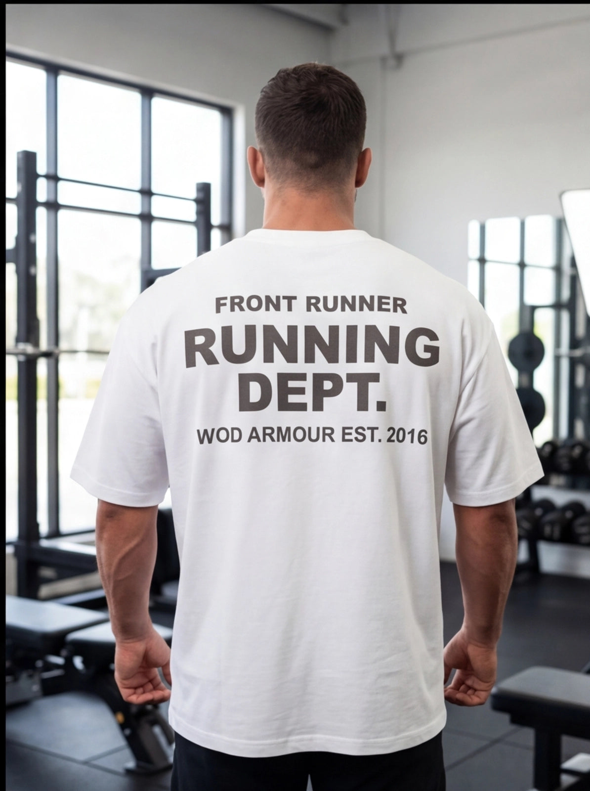 Man wearing white 'Front Runner Running Dept.' gym t-shirt, WOD Armour fitness apparel, back view in gym