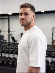 Athlete in white gym shirt at functional fitness gym with dumbbells and equipment