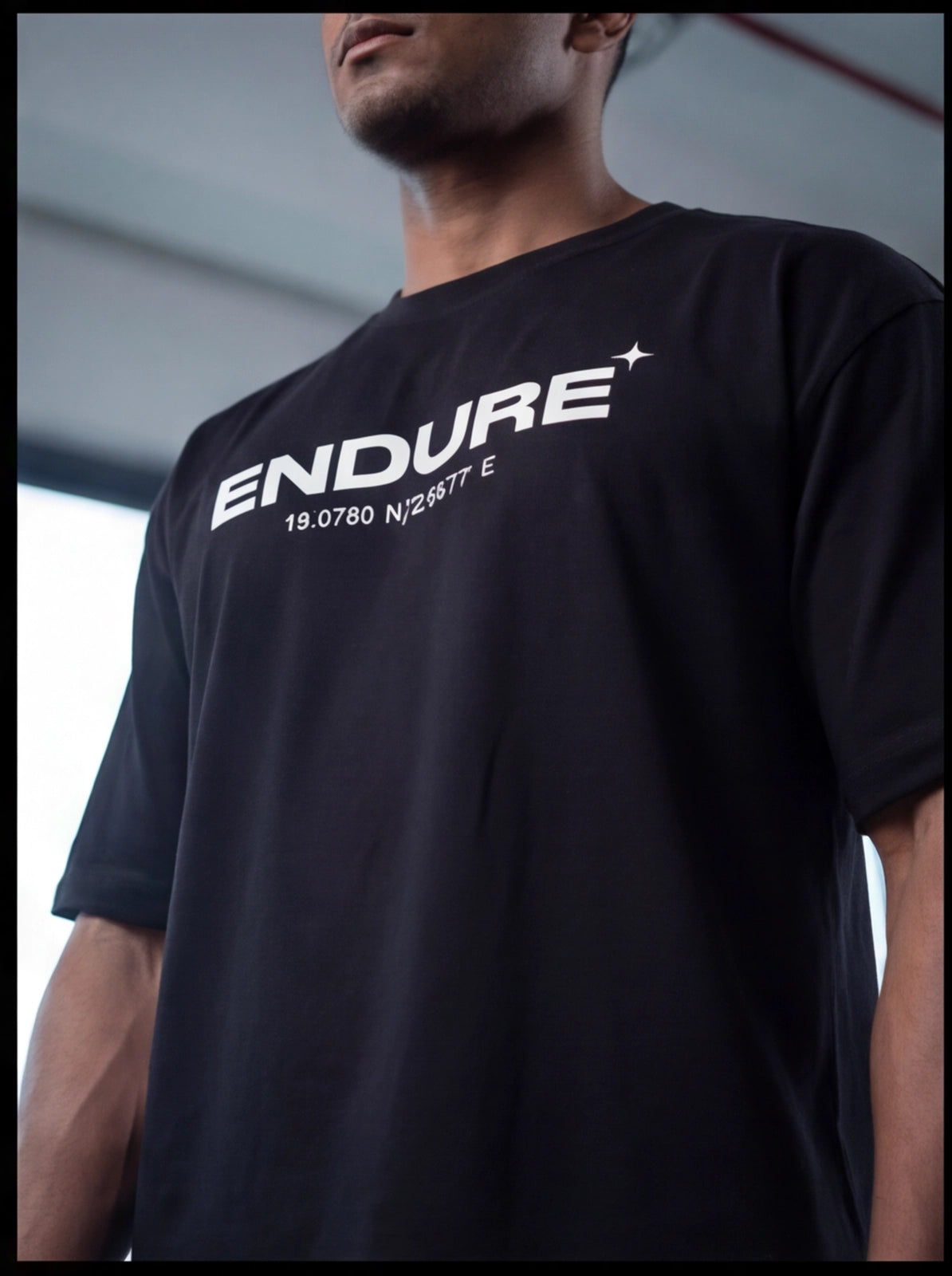 Black ENDURE fitness t-shirt with coordinates, worn by athlete in gym setting for functional training