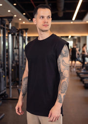 Man in black sleeveless gym shirt at functional fitness gym, showcasing athletic wear for training