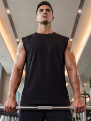 Athlete lifting barbell in gym wearing black sleeveless fitness shirt for strength training