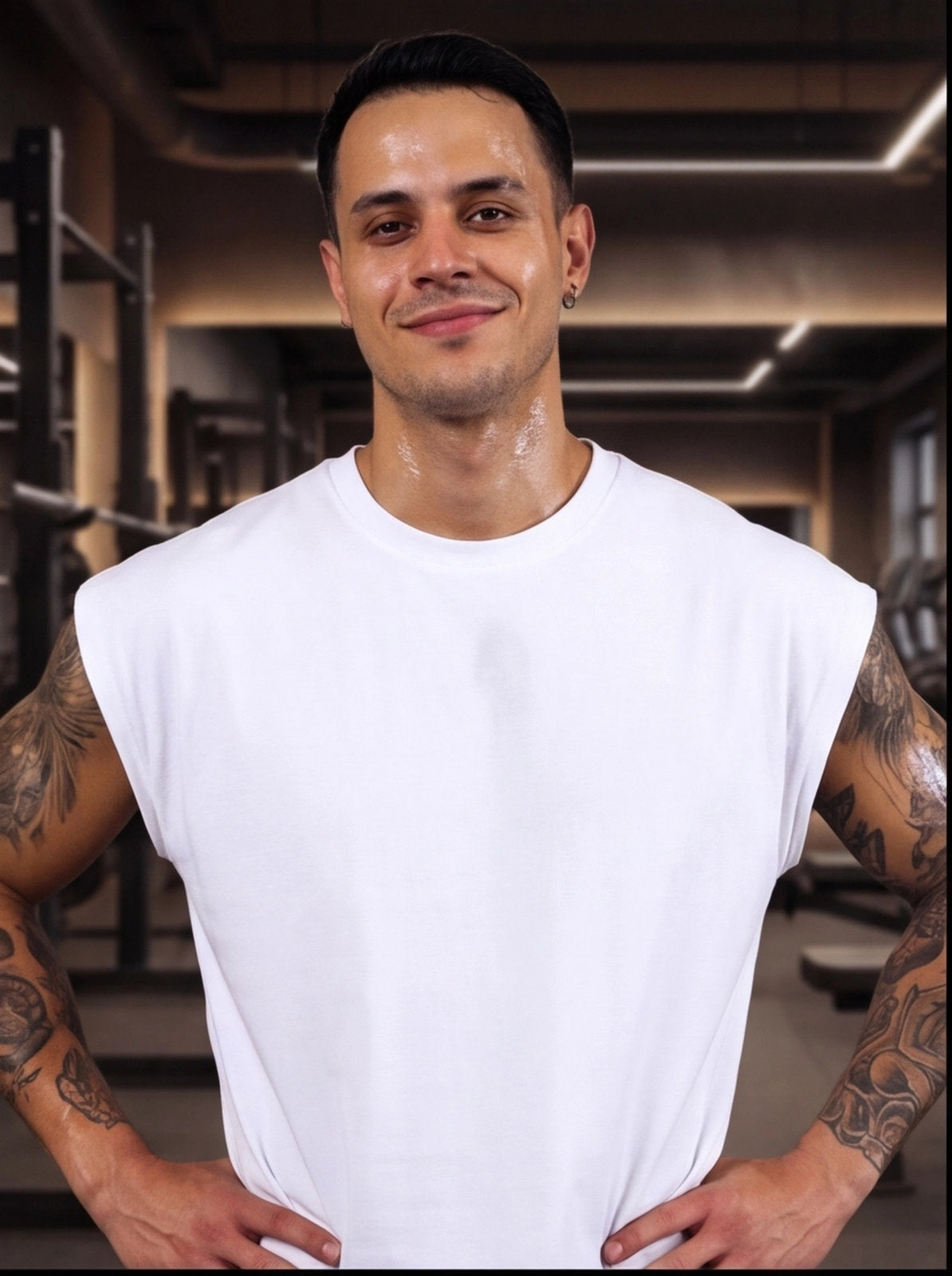 Man in white sleeveless gym shirt, sweating after workout, tattoos visible, functional fitness apparel