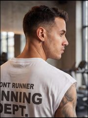 Man in gym wearing white 'Front Runner Running Dept.' t-shirt, showcasing athletic fitness apparel for performance training.