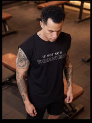 Man in gym wearing black sleeveless fitness shirt with 'IF NOT NOW THEN, WHEN?' text, ideal for functional training.