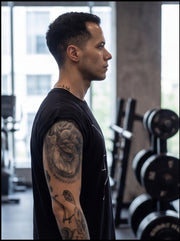 Athlete in gym with tattooed arm, focused on functional fitness training