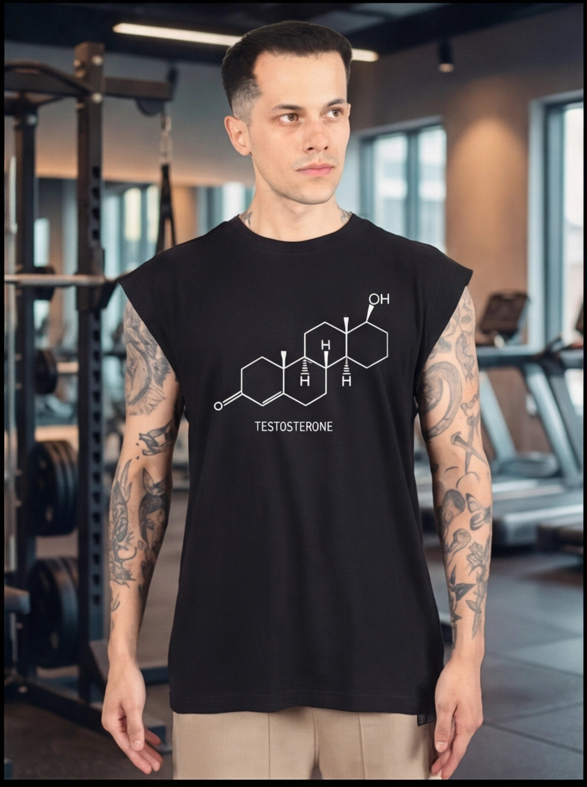 Man in gym wearing black sleeveless shirt with testosterone molecule graphic, fitness apparel for athletes.