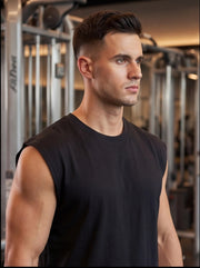 Athlete in black sleeveless gym shirt, focused in fitness center with strength training equipment