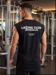 Man wearing black 'Lifting Club Worldwide' gym tank top in fitness center