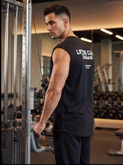 Man in gym using cable machine, wearing black 'Lifting Club Worldwide' tank top for functional fitness training.