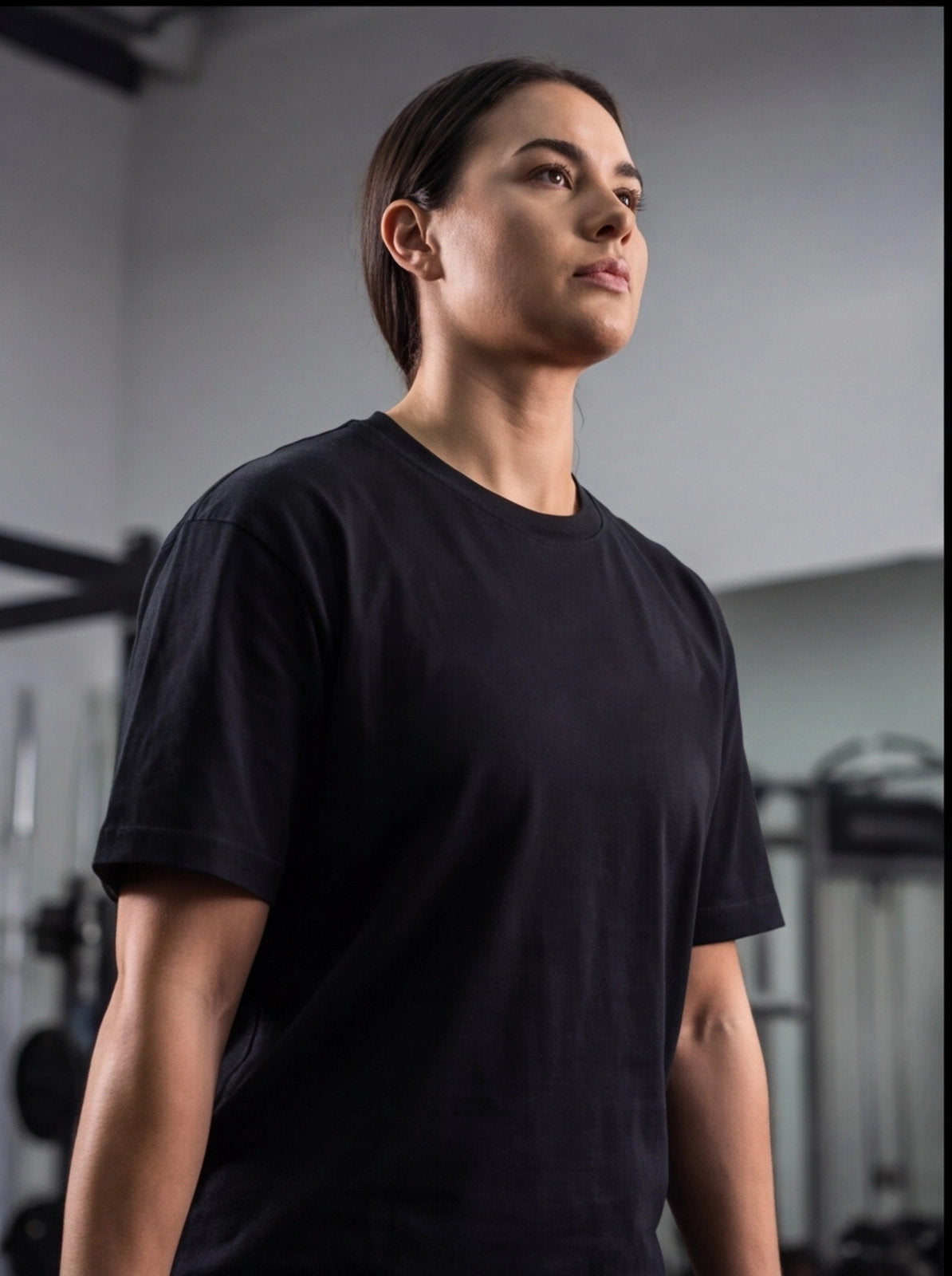 Woman in black gym t-shirt at functional fitness facility, ready for workout