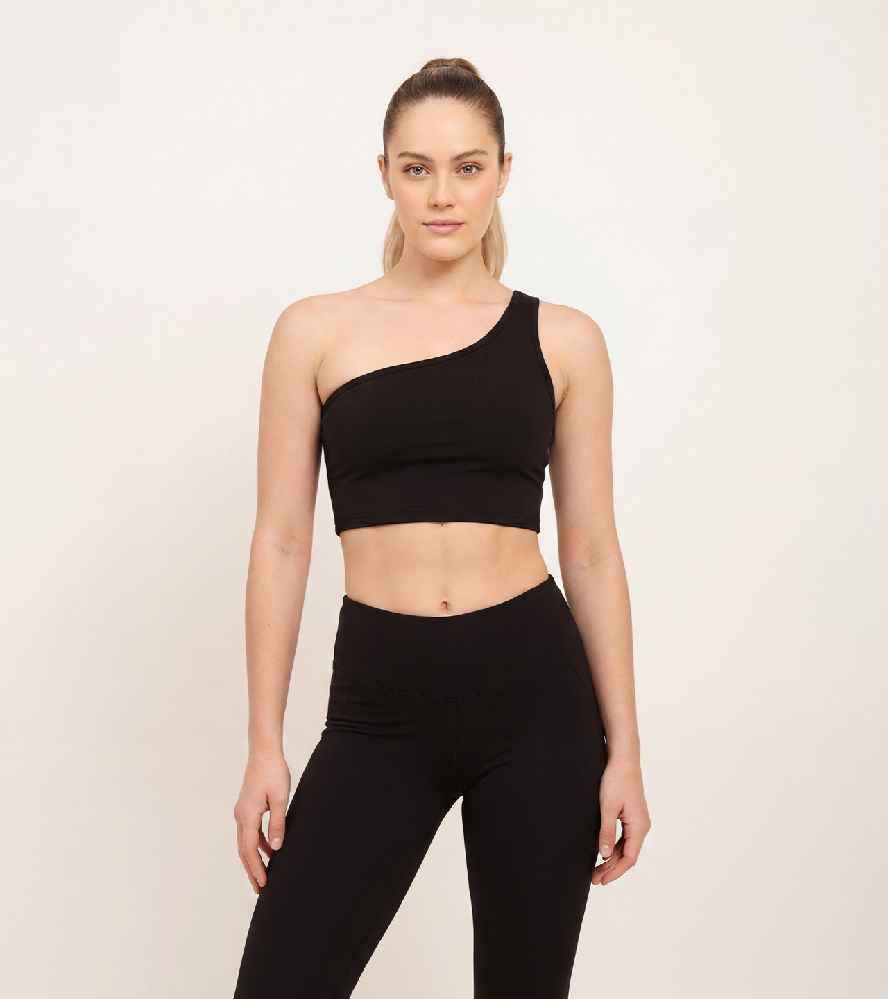 Black one-shoulder crop top and high-waisted leggings for functional fitness training