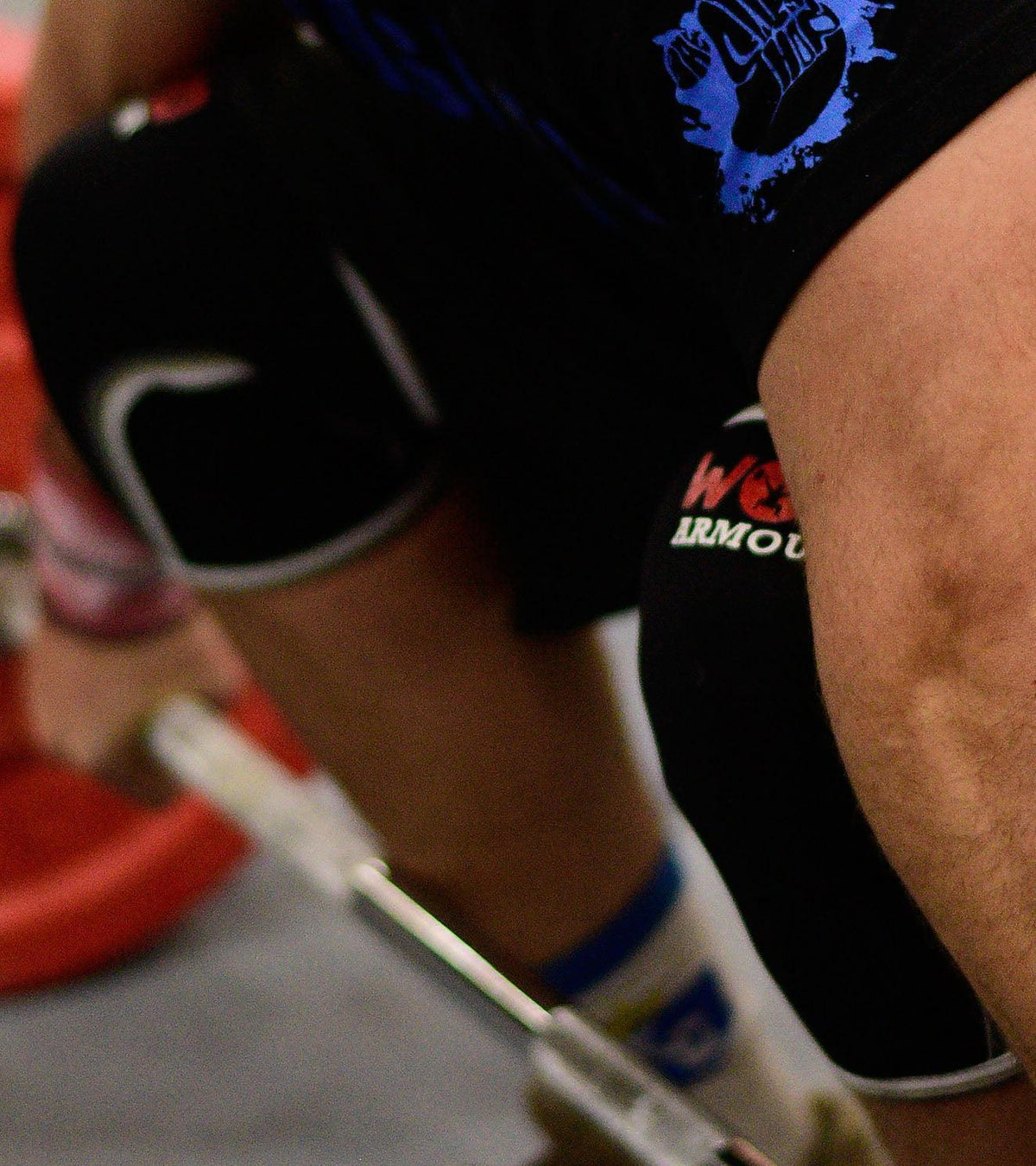 Close-up of an athlete wearing black WODARMOUR knee sleeves during functional fitness training.