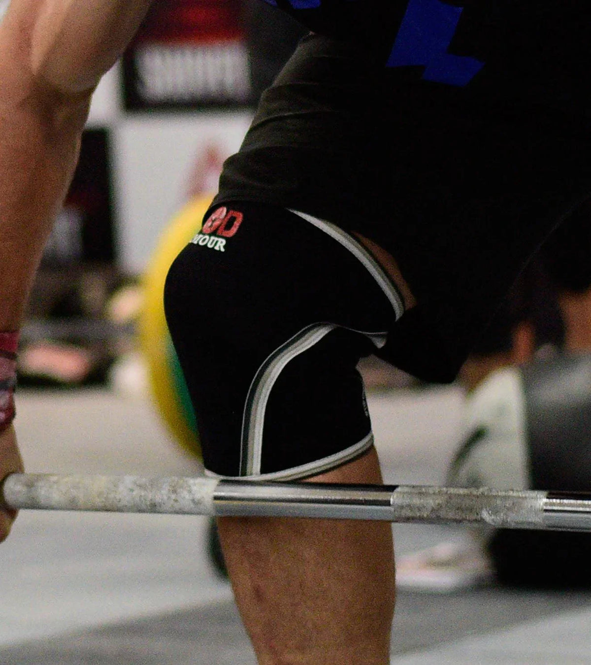 Athlete wearing black compression knee sleeves during a weightlifting workout.